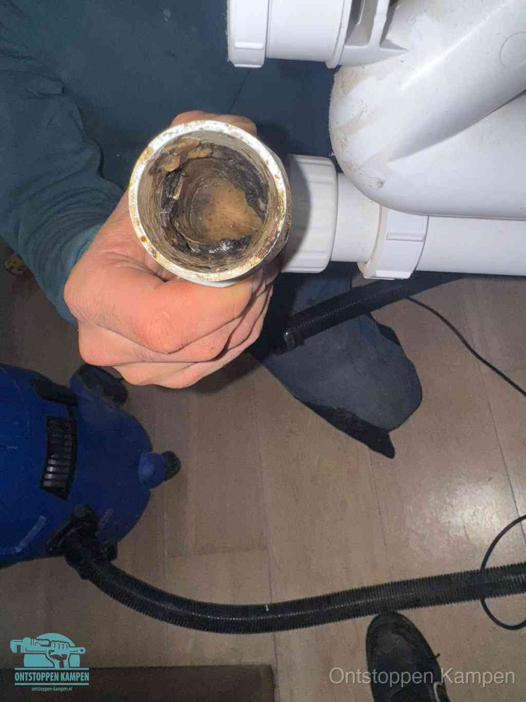 Een losgekoppeld afvoerbuisstuk dat van binnen volledig is dichtgeslibd, het gevolg van een verstopping te lang laten zitten in Kampen