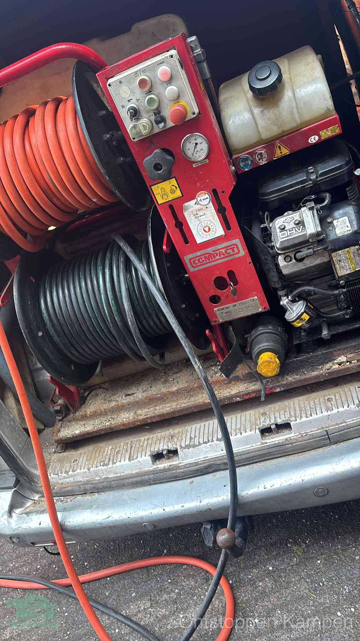 Een rood hogedruk-rioolreinigingstoestel in de laadbak van de bedrijfsbus, apparatuur voor een hardnekkige afvoerverstopping in Kampen