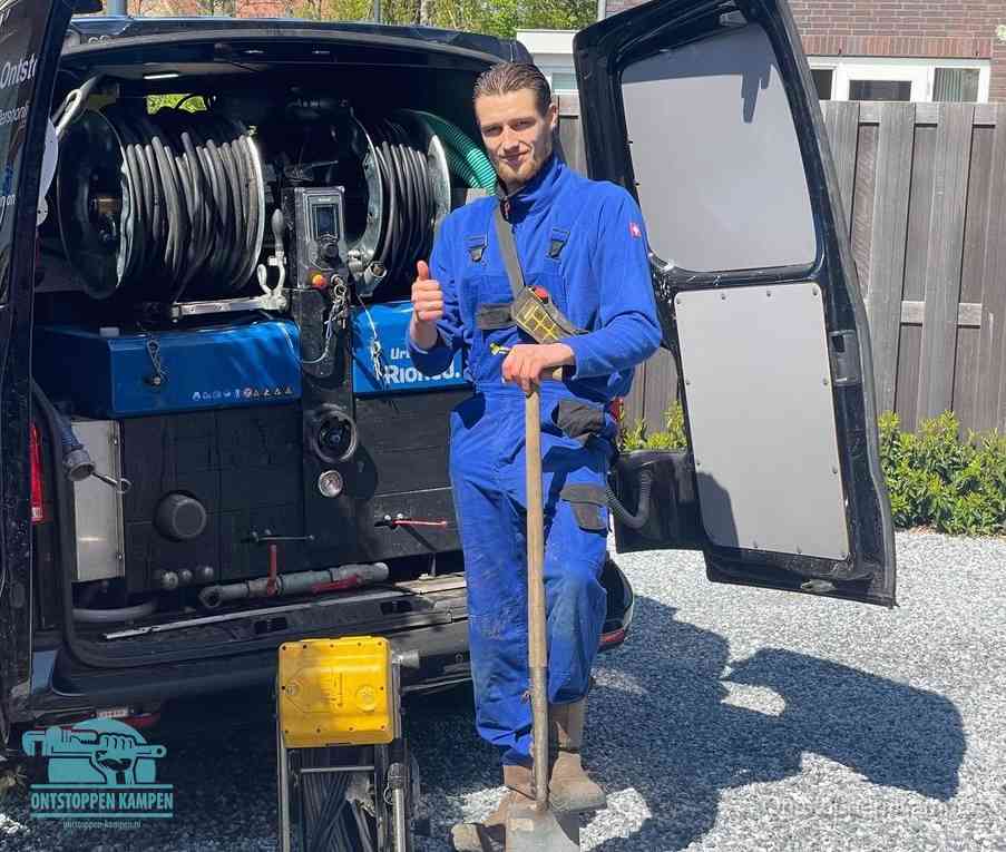 Een monteur bij de werkbus met grote hogedruk-slanghaspels, apparatuur voor hardnekkige afvoerverstoppingen in Kampen