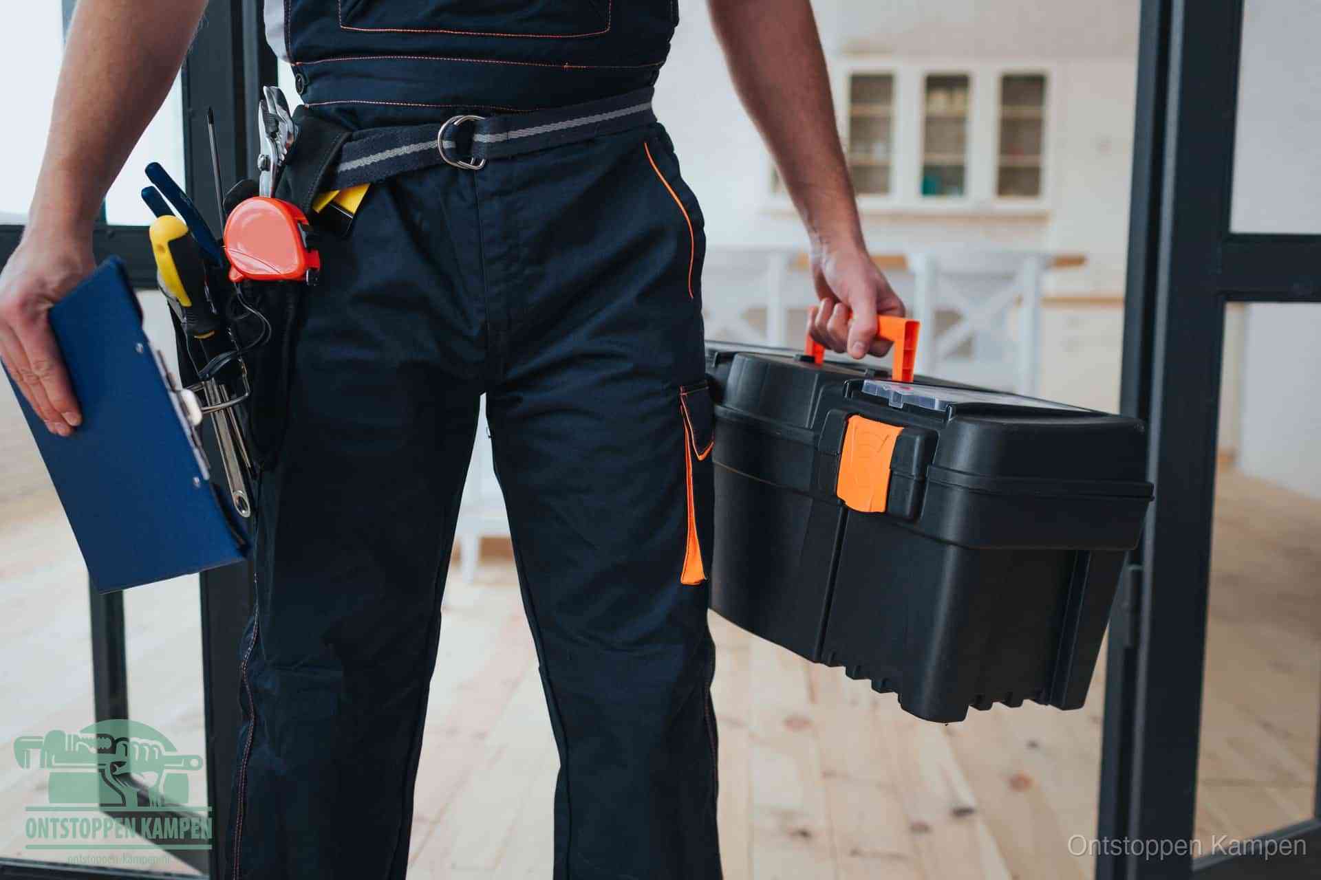 Een monteur met gereedschapsriem en klembord, klaar om een transparante prijs voor het afvoer ontstoppen in Kampen te geven