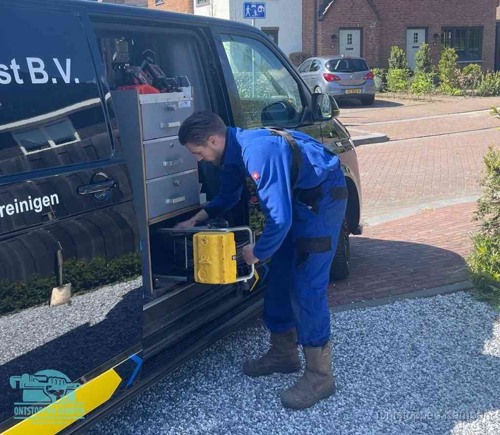 Een monteur pakt apparatuur uit de bedrijfsbus voor service aan huis, het moment om een professional in te schakelen in Kampen